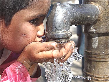 A flood victim drinks water from a hand pump in Murad Chandio village.