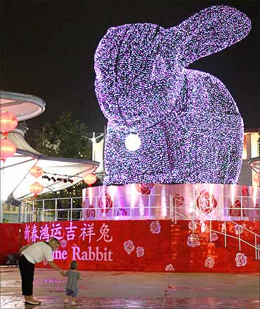 A mother, daughter stand in front of a four-storey-high topiary rabbit at Resorts World Sentosa.