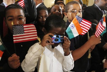 Guests hold the flags of the United States and India as U.S. President Barack Obama welcomes Indian Prime Minister Manmohan Singh.