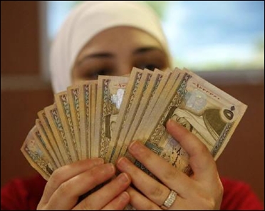 An employee counts Jordanian dinars at the Jordan Dubai Islamic Bank head office in Amman.