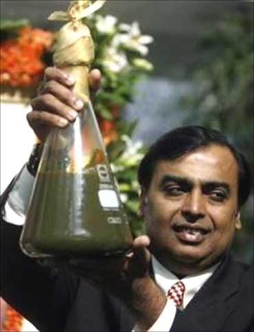 Mukesh Ambani, Chairman of Reliance Industries, holds a jar containing the first crude oil produced from the company's KG-D6 block.