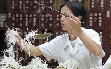A Chinese pharmacist fills a prescription of Chinese herbal medicine at a herbal medicine store.