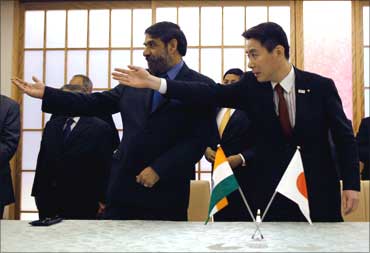 Trade Minister Anand Sharma (L) and Japan's Foreign Minister Seiji Maehara gesture after signing the Comprehensive Economic Partnership Agreement (CEPA) in Tokyo February 16, 2011.