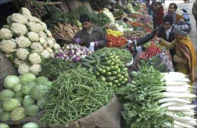 People buy vegetables at a market in Jammu.