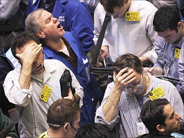 Traders work in the oil options pit on the floor of the New York Mercantile Exchange in New York City. World stocks fell as a growing revolt in Libya drove oil prices to 30-month highs.