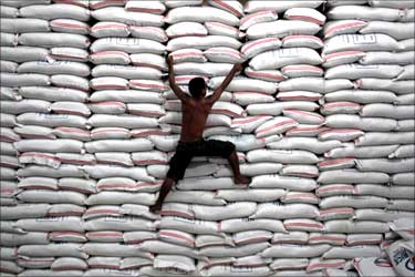 A worker climbs on a pile of rice stock inside a warehouse in Bicutan, south of Manila, the Philippines.