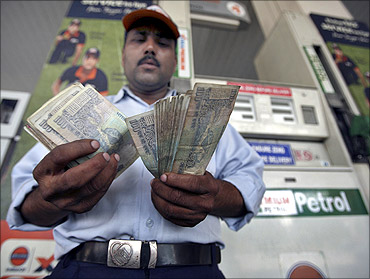A worker at a gas station counts currency notes in Jammu.