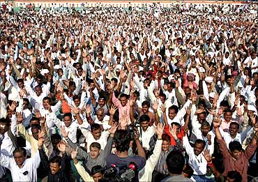 Employees of the state government raise their hands during a protest rally in Ahmedabad.