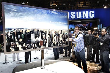 A reporter touches a 75-inch, full HD 3D LED television by Samsung Electronics.