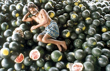 An Indian farmer sleeps on watermelons in Siliguri.
