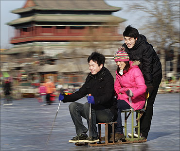 People ride a specially constructed 'ice-chair' on a frozen lake in front of Drum Tower in Beijing.