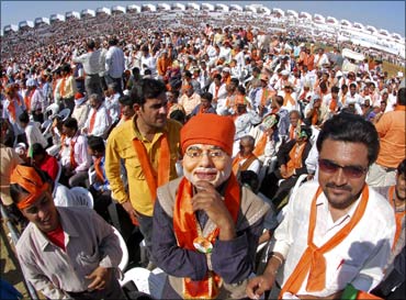 A Bharatiya Janata Party supporter wears a mask of Gujarat's Chief Minister Narendra Modi.