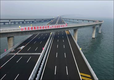 A sign that reads: 'Shandong Highway Corp. invests to operate Shandong Highway Jiaozhou Bay Bridge' is seen at Qingdao Jiaozhou Bay Bridge in Qingdao, Shandong province.