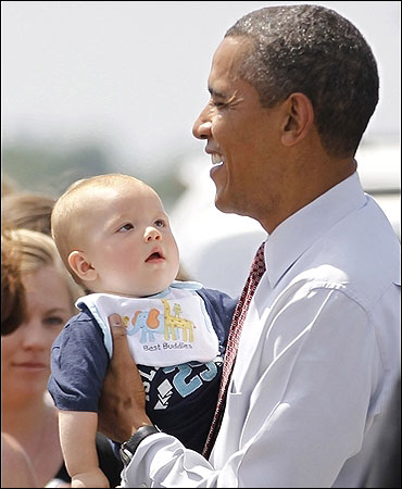 US President Barack Obama holds a baby during his visit to Fort Drum in New York.