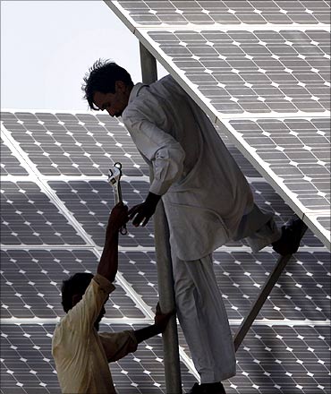 Technicians work on solar panel in power station at Hub about 25 km (15 miles) from Karachi.