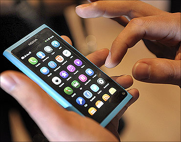 A staff member displays a Nokia N9 smartphone at a news conference in Espoo.