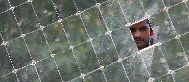 A worker looks through a solar panel at the Gadhia solar energy systems manufacturing unit at Gundla
