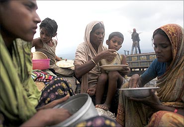 Stone worker Sajeda Begum eats lunch with her son Sohel during a break in work at Bholaganj.