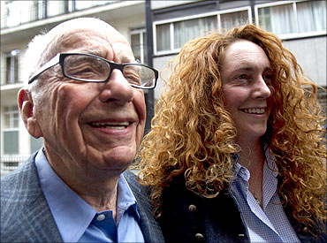 News Corporation CEO Rupert Murdoch leaves his flat with Rebekah Brooks, chief executive of News International, in central London.