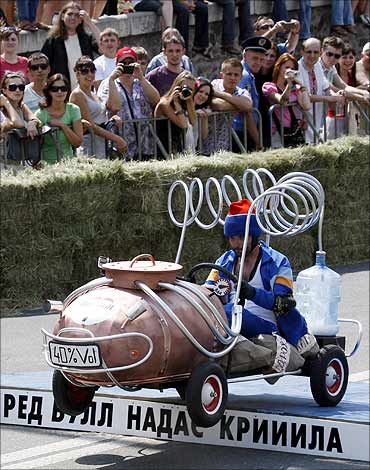 A participant in handmade cart in the form of a distillation apparatus takes part in Red Bull Rally.