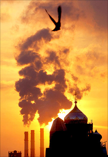 Smoke rises into the sky, as a cathedral is silhouetted against the sunset in St.Petersburg.