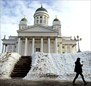 A woman walks past the Helsinki cathedral.