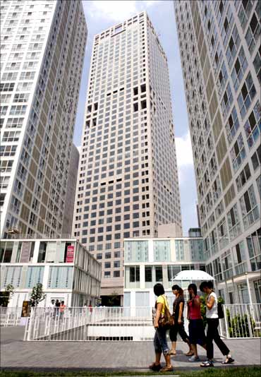 Women walk past buildings at Beijing's central business district.