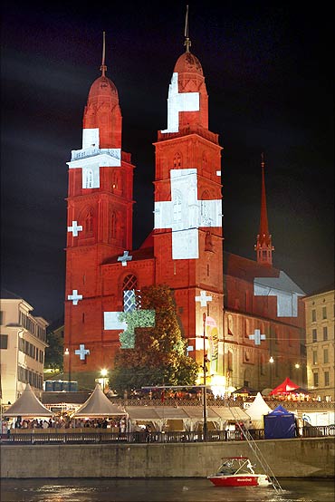 A light installation by Swiss artist Gerry Hofstetter illuminates the Grossmunster church in Zurich.