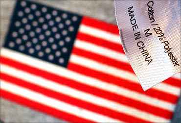 The label reading 'Made in China' on a sweatshirt is seen over another shirt with a U.S. flag at a souvenir stand in Boston.