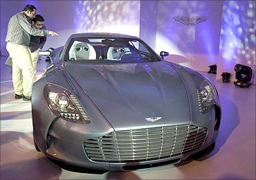 People look at an Aston Martin One-77 displayed on a stage in Mumbai.