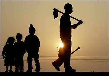 A labourer carrying his tools is silhouetted against the setting sun in Chandigarh.