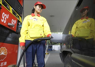 A station attendant fills up a car at a PetroChina gas station in Beijing.