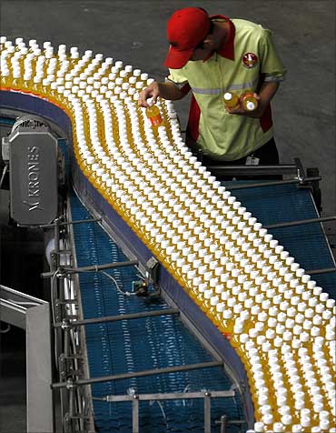 A worker checks drink bottles at PT Coca-Cola Amatil Indonesia's factory in Cibitung.