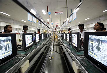 Workers at LG Electronics India Pvt Ltd. assemble television sets inside a factory.