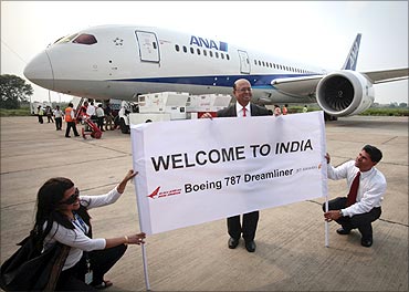 Boeing India President Dinesh Keskar (C) poses in front of the Boeing 787 Dreamliner in Delhi.