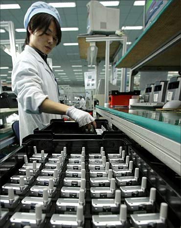 A Chinese worker checks mobile phones at a production line of Ningbo Bird Co.
