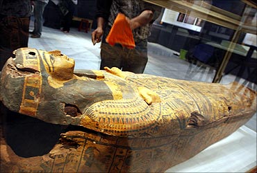 A worker in the Egyptian Museum cleans the display case of the Miami Coffin in Cairo