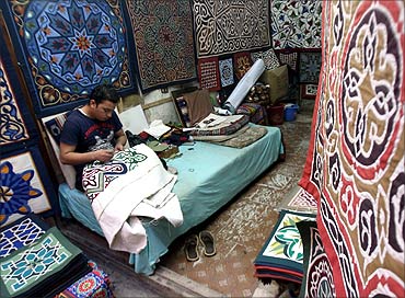 An Egyptian tentmaker sews in his shop during the Muslim fasting month of Ramadan, on the Street of the Tentmakers, in the historic quarter of Cairo.