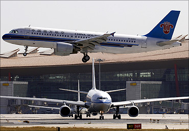 Air China plane waits on tarmac as a China Southern Airbus plane lands at Beijing Airport.