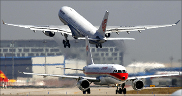 A China Eastern Airlines plane sits on the tarmac as an Air China plane takes off at Beijing Airport