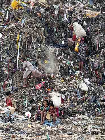 Children collect recyclable material at a dump in New Delhi