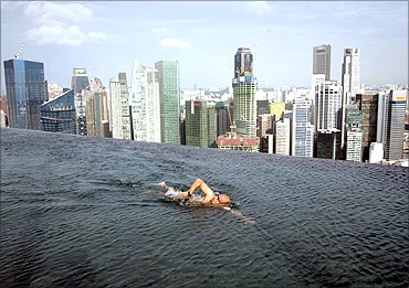 A guest swims in the infinity pool of the Skypark that tops the Marina Bay Sands hotel towers.