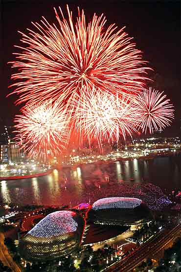 Fireworks explode over Marina Bay and the Esplanade theatres.