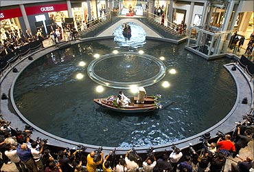 A newlywed couple takes a sampan ride on a canal inside a shopping centre at the Marina Bay Sands.