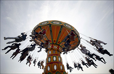 Visitors enjoy a ride at an amusement park in Noida,