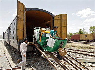 A new auto rickshaw is unloaded from a goods train at a storage facility at Sanand