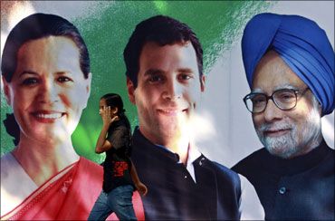 A girl walks past a Congress party banner showing pictures of Sonia and Rahul Gandhi and Prime Minister Manmohan Singh.