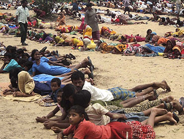 Villagers and their children lie at the proposed Posco site during a protest.