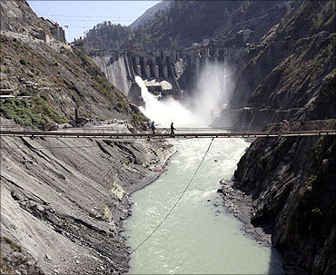 Labourers walk on a bridge near the hydropower project located at Baglihar Dam.