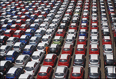 An employee walks between parked Hyundai cars ready for shipment.